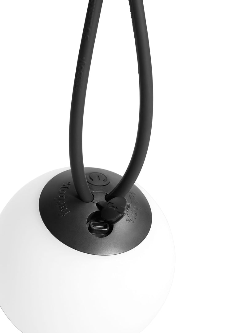 Vue rapprochée de la Bolleke la Surprise suspendue dehors par sa boucle en silicone.