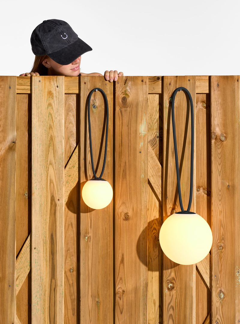 Lampe rechargeable Bolleke la Surprise suspendue à un crochet, émettant une lumière chaude.
