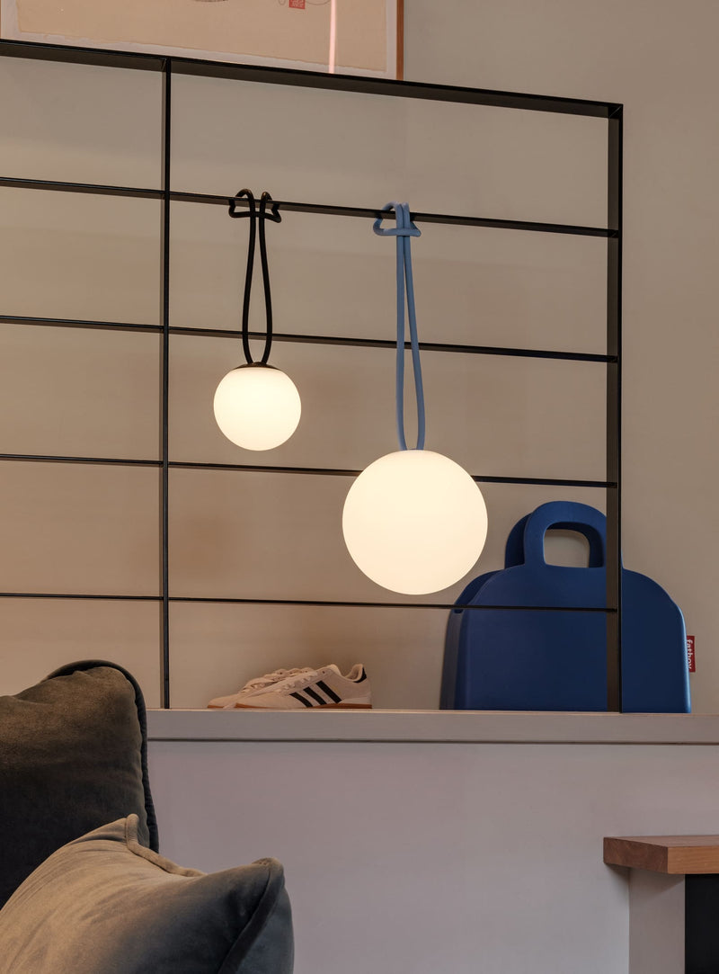 Lampe Bolleke la Surprise suspendue dans un couloir, diffusant une lumière d’ambiance tamisée.