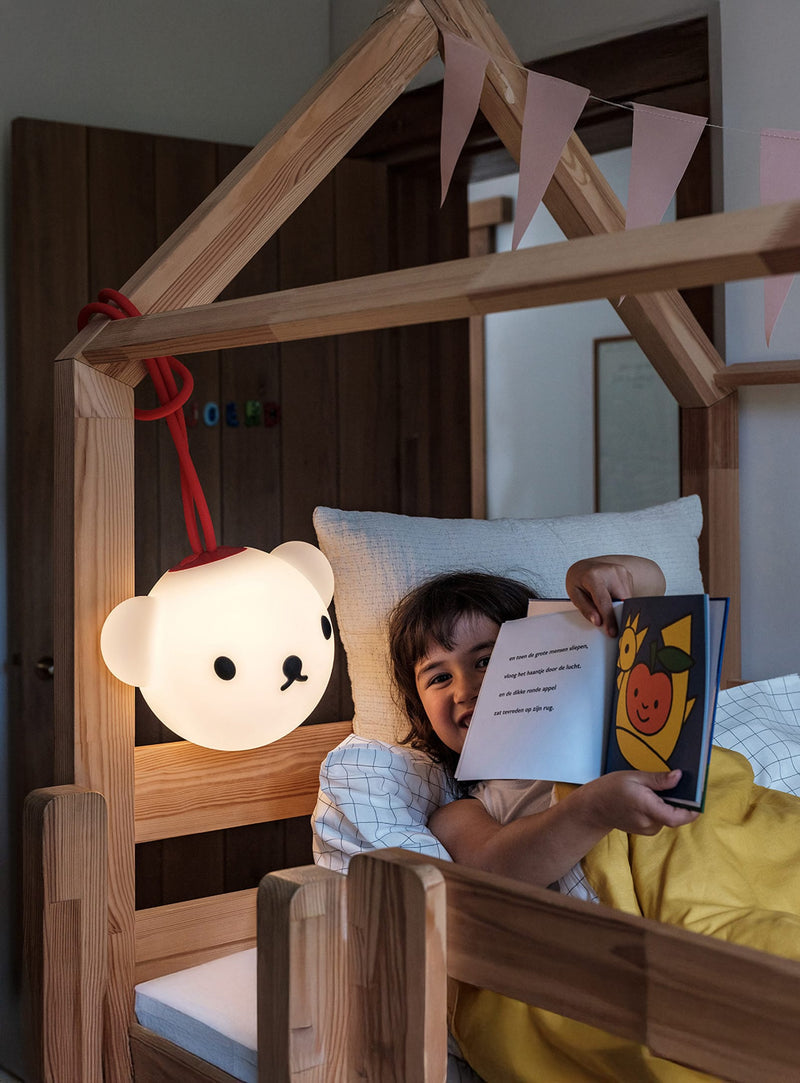 Lampe Bolleke x Boris de Fatboy diffusant une lueur chaleureuse dans un salon ou un coin lecture.