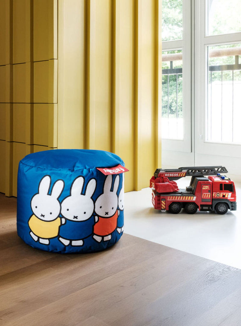 Pouf Point x Miffy de Fatboy dans une salle de jeux pour enfants, avec camion de pompier.