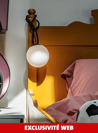 Bolleke Mini de Fatboy accrochée à une tête de lit, créant une atmosphère cosy dans la chambre.