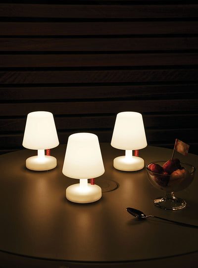 Ensemble de trois lampes 'Edison the Mini' sur une table, émettant une douce lumière LED blanche et chaude, adaptées pour un usage intérieur et extérieur.
